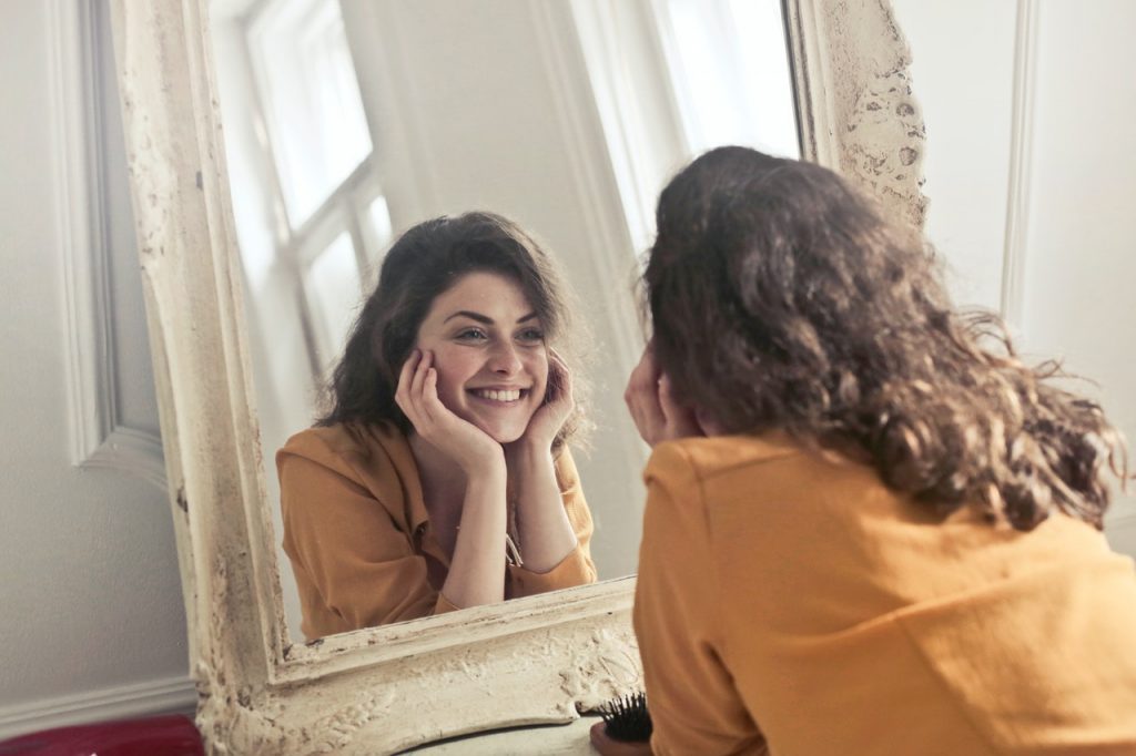 person smiling in front of mirror
